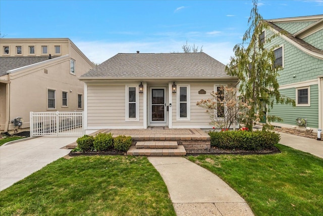 bungalow-style house with fence, a front yard, a porch, and a shingled roof