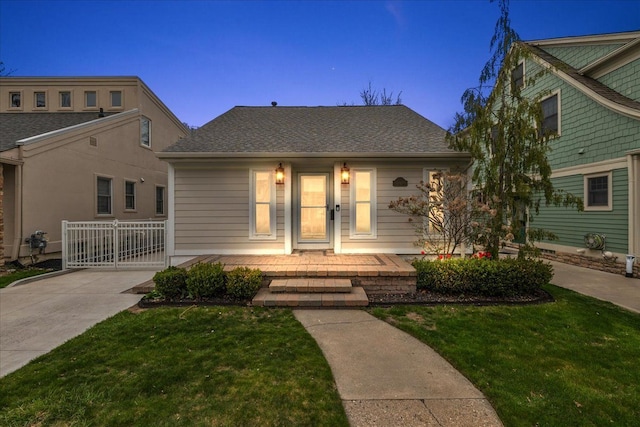 bungalow-style house featuring a porch, a shingled roof, and a front lawn