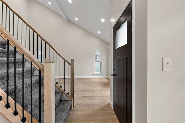 entrance foyer featuring light wood-style flooring, beamed ceiling, recessed lighting, high vaulted ceiling, and stairs