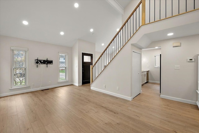 entryway featuring stairs, visible vents, light wood-style floors, and plenty of natural light