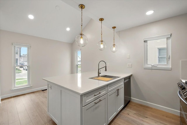 kitchen featuring light wood-style flooring, a sink, a peninsula, and baseboards