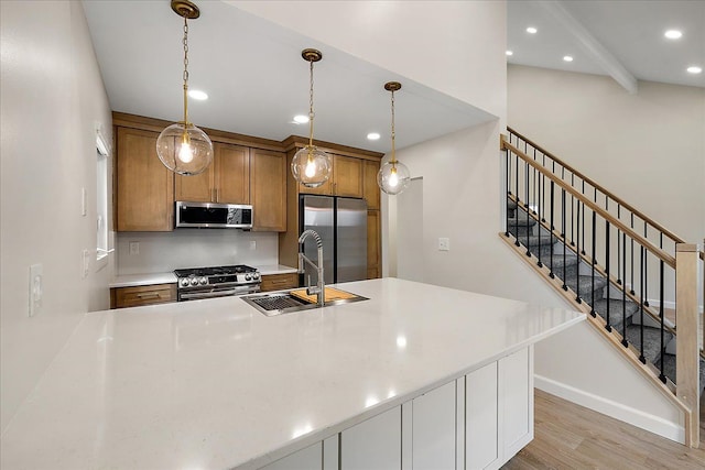 kitchen with recessed lighting, a sink, brown cabinets, stainless steel appliances, and light wood-style flooring