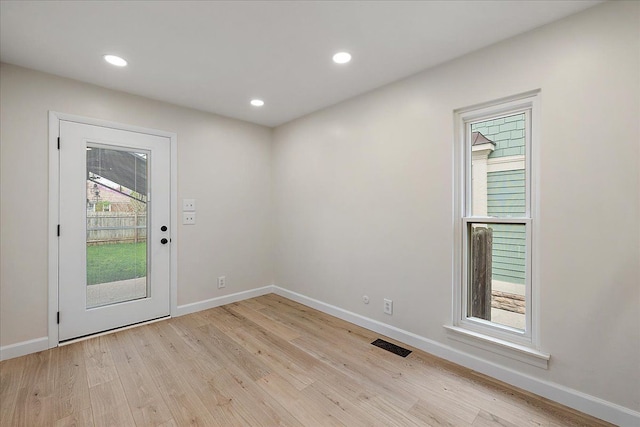 foyer featuring visible vents, baseboards, and light wood-type flooring