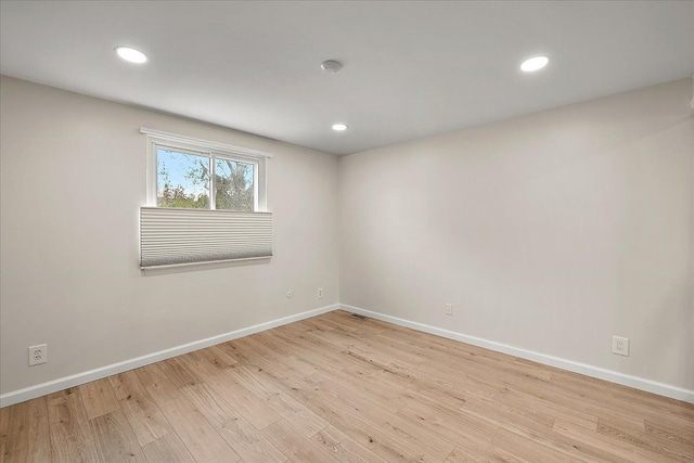 unfurnished room with recessed lighting, wood finished floors, and baseboards