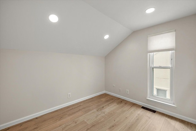 additional living space featuring recessed lighting, light wood-style flooring, baseboards, visible vents, and lofted ceiling