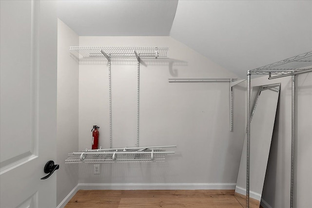 spacious closet featuring wood finished floors and vaulted ceiling