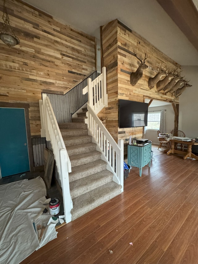 stairs with wood walls and hardwood / wood-style floors