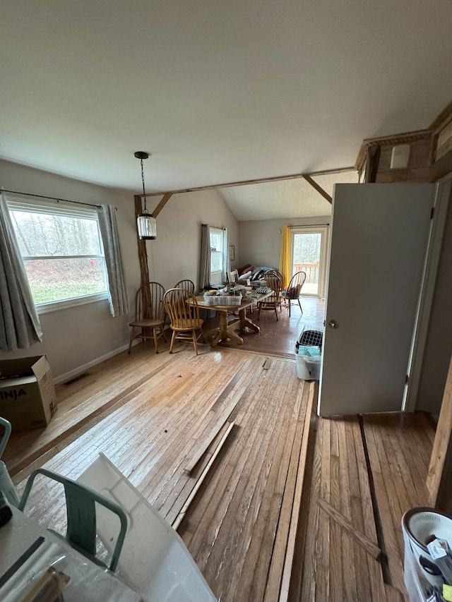 dining area with visible vents, hardwood / wood-style flooring, and lofted ceiling