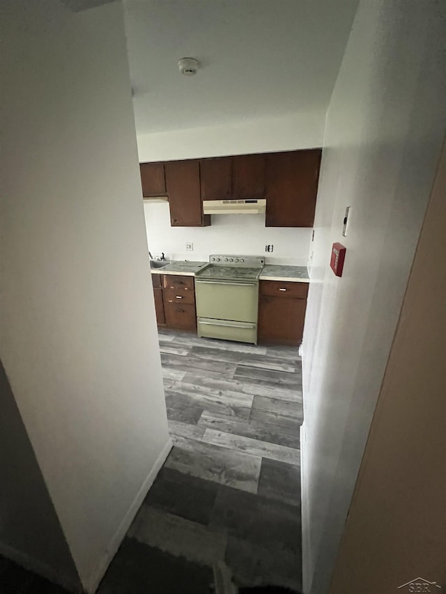 3197 Studor Rd, Saginaw, MI 48601 - kitchen with light floors, light countertops, electric range, baseboards, and under cabinet range hood