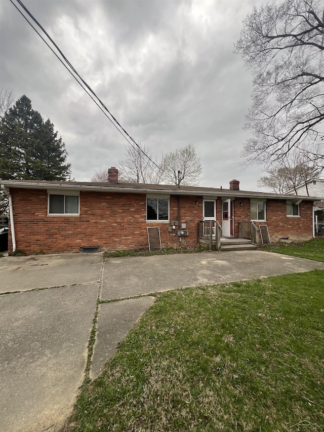 3197 Studor Rd, Saginaw, MI 48601 - view of front of property featuring a front lawn, a chimney, and brick siding