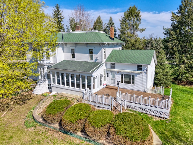 11811 Laird Rd, Brooklyn, MI 49230 - back of house with a chimney, a shingled roof, a wooden deck, a sunroom, and a lawn