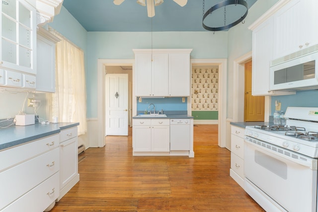 11811 Laird Rd, Brooklyn, MI 49230 - kitchen with dark countertops, white appliances, white cabinets, and a sink