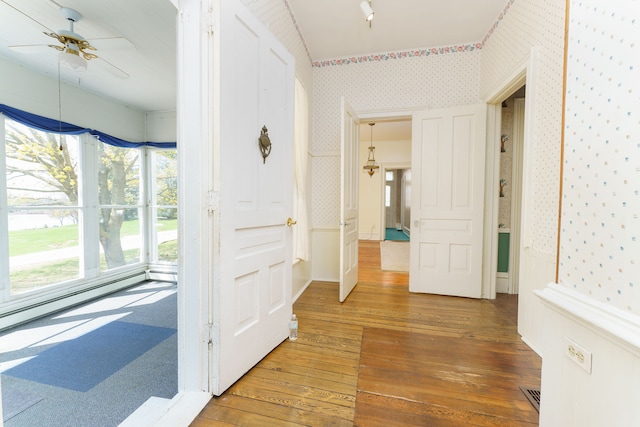 11811 Laird Rd, Brooklyn, MI 49230 - hall with wallpapered walls, a wealth of natural light, wood-type flooring, and a baseboard heating unit
