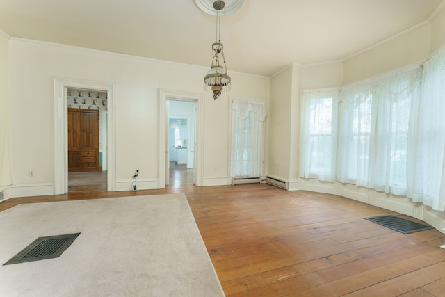 11811 Laird Rd, Brooklyn, MI 49230 - unfurnished dining area featuring wood-type flooring, crown molding, visible vents, baseboards, and a baseboard radiator