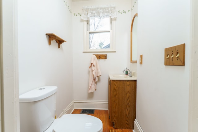 11811 Laird Rd, Brooklyn, MI 49230 - bathroom with visible vents, baseboards, toilet, wood finished floors, and vanity
