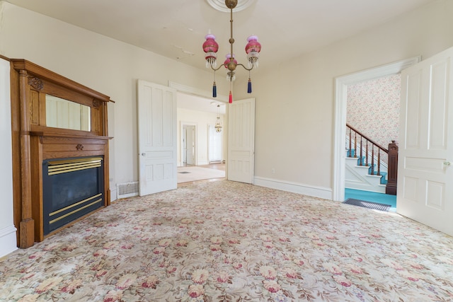 11811 Laird Rd, Brooklyn, MI 49230 - unfurnished living room featuring stairs, an inviting chandelier, carpet floors, and a glass covered fireplace