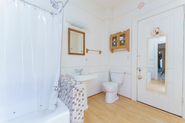 11811 Laird Rd, Brooklyn, MI 49230 - bathroom featuring toilet, a sink, shower / bath combo with shower curtain, and wood finished floors