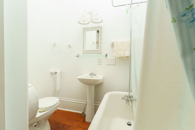 11811 Laird Rd, Brooklyn, MI 49230 - full bathroom with wood finished floors, toilet, a bathtub, baseboards, and curtained shower
