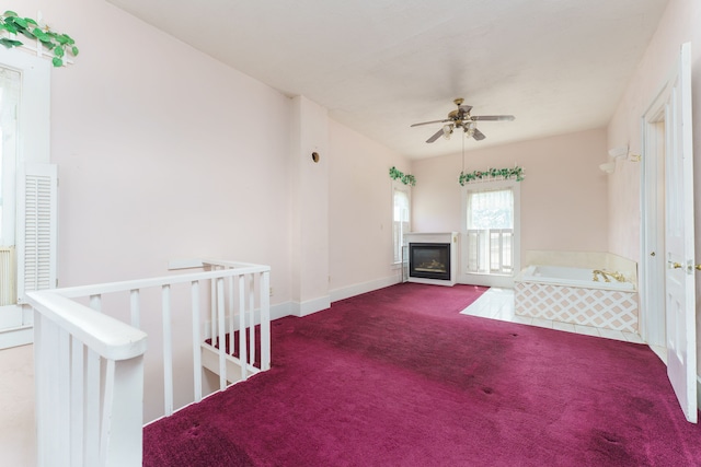 11811 Laird Rd, Brooklyn, MI 49230 - unfurnished living room featuring a glass covered fireplace, ceiling fan, carpet flooring, and baseboards