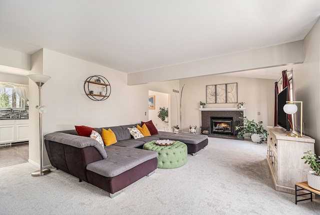 living area with carpet flooring and a fireplace with flush hearth