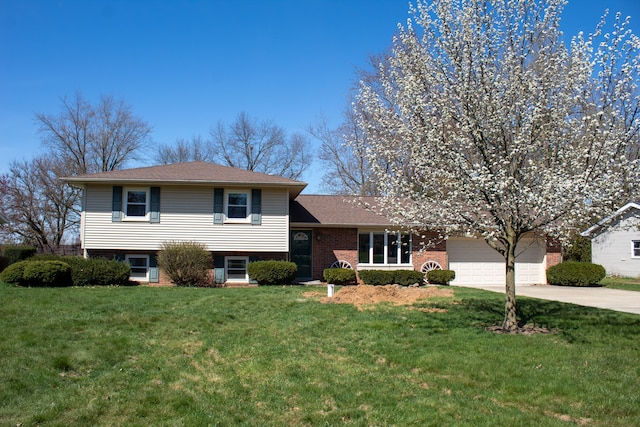 tri-level home with brick siding, a garage, a front lawn, and driveway