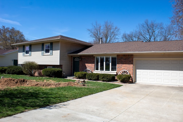 tri-level home with a garage, a front yard, brick siding, a shingled roof, and driveway