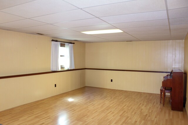 empty room featuring a paneled ceiling and wood finished floors