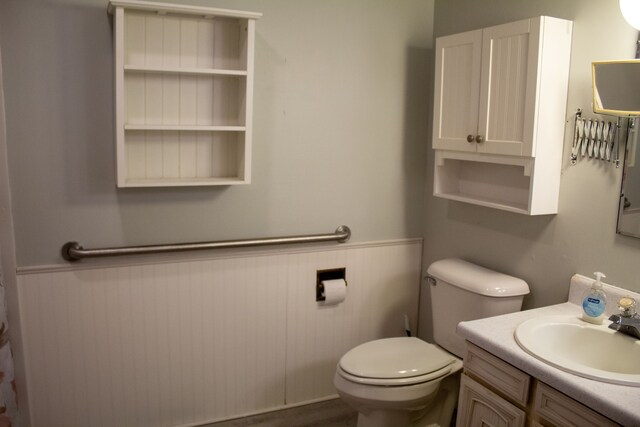 bathroom with vanity, wainscoting, and toilet