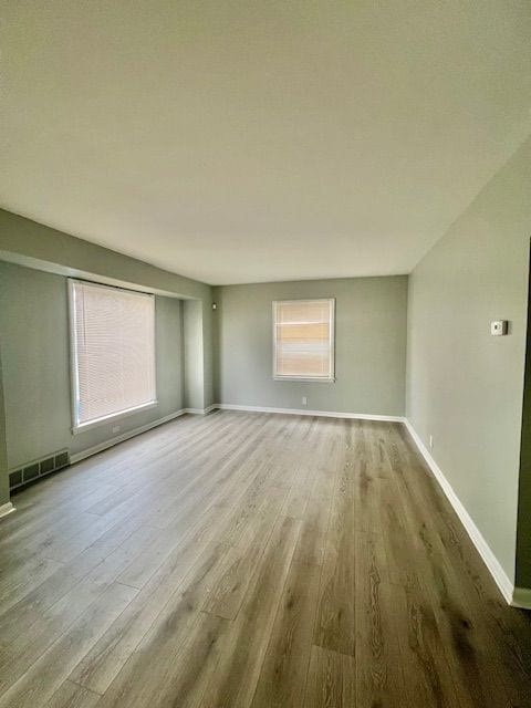 19676 Kingsville St, Harper Woods, MI 48225 - unfurnished living room featuring baseboards, wood finished floors, and visible vents