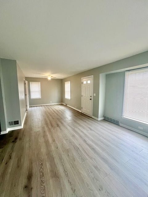 19676 Kingsville St, Harper Woods, MI 48225 - unfurnished living room featuring wood finished floors, visible vents, and baseboards