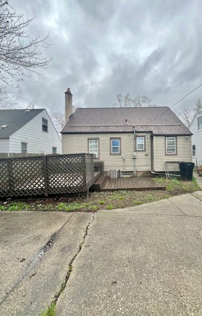 19676 Kingsville St, Harper Woods, MI 48225 - rear view of property featuring a chimney, fence, and a deck