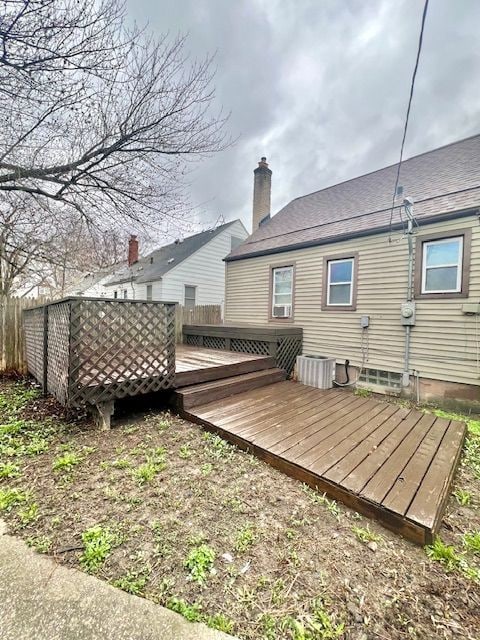 19676 Kingsville St, Harper Woods, MI 48225 - back of house featuring fence, a wooden deck, and a chimney