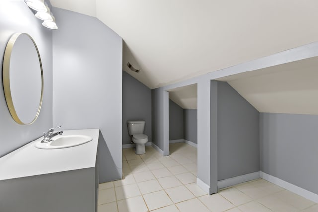 5580 Hegel Rd, Goodrich, MI 48438 - bathroom with lofted ceiling, toilet, vanity, visible vents, and tile patterned flooring