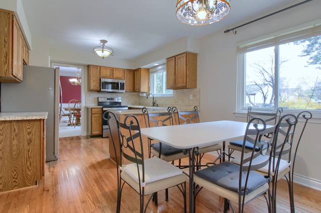 dining area featuring light wood finished floors and a notable chandelier