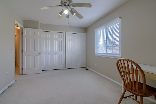 living area with ceiling fan, baseboards, and carpet flooring