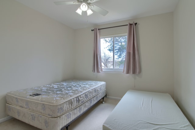 carpeted bedroom with ceiling fan and baseboards