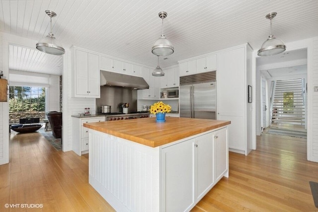 kitchen featuring under cabinet range hood, appliances with stainless steel finishes, light wood-style floors, and white cabinetry