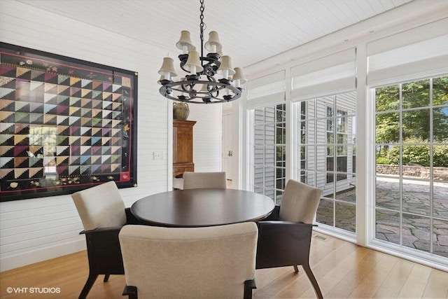 dining area with wood finished floors and a notable chandelier