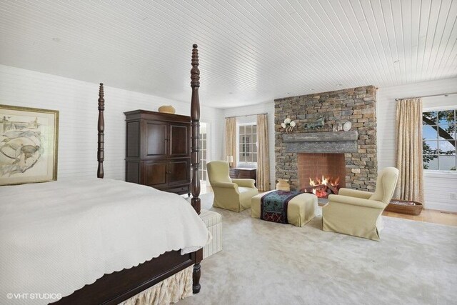 bedroom featuring a stone fireplace