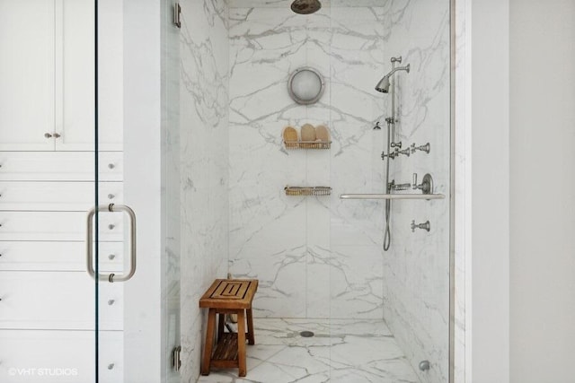 bathroom featuring a marble finish shower
