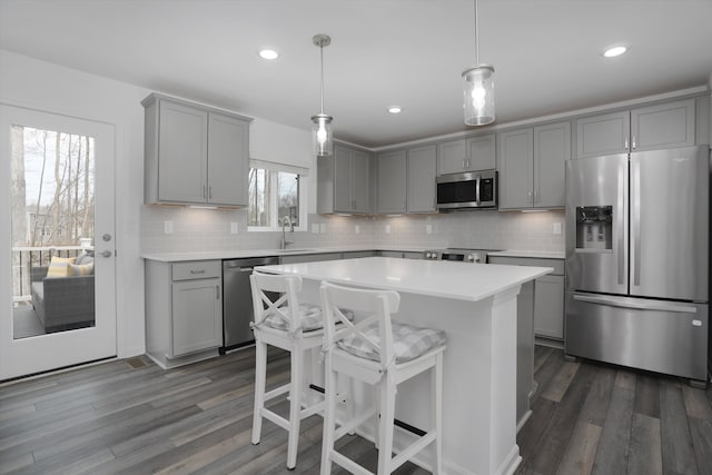 kitchen with light countertops, stainless steel appliances, a sink, and gray cabinets
