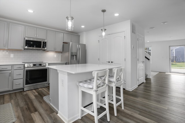 kitchen featuring light countertops, gray cabinetry, appliances with stainless steel finishes, and visible vents