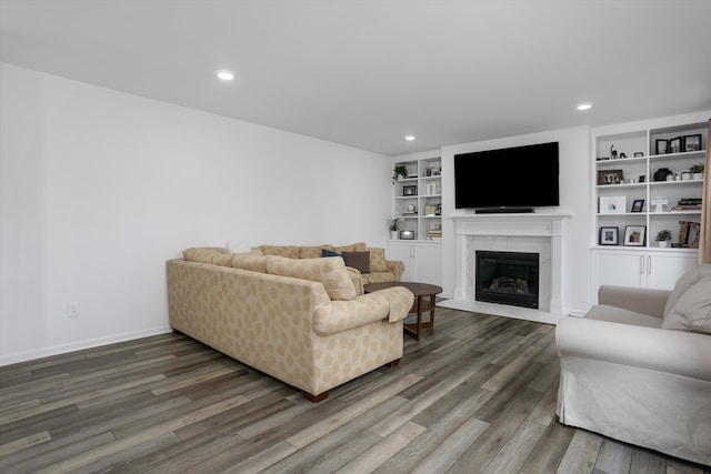 living room with recessed lighting, baseboards, a glass covered fireplace, and wood finished floors