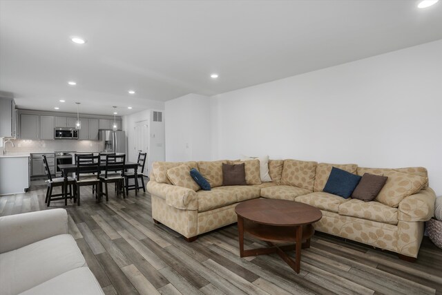 living area featuring dark wood-style flooring, recessed lighting, and visible vents