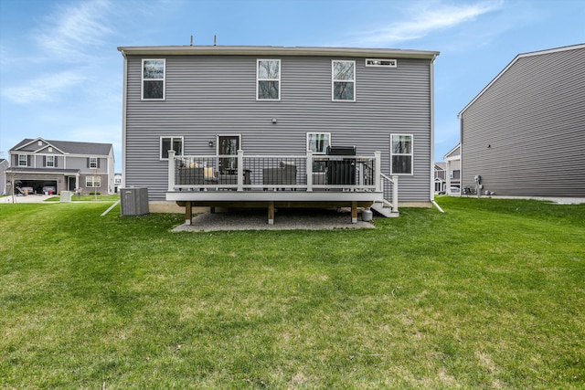 rear view of house with a lawn, central AC, and a deck