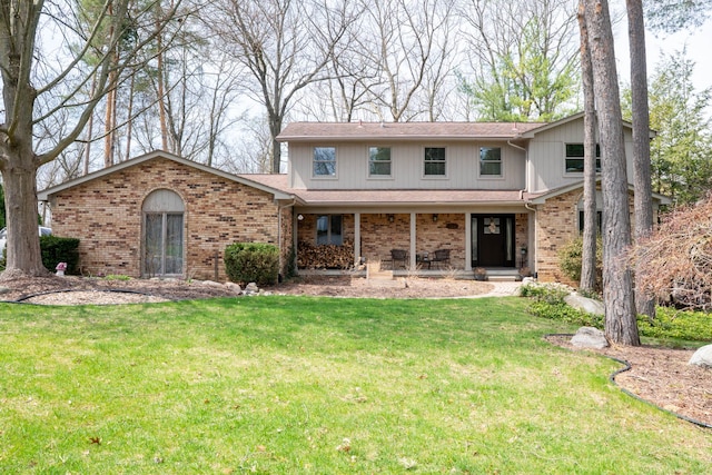 traditional-style home featuring covered porch, brick siding, and a front yard