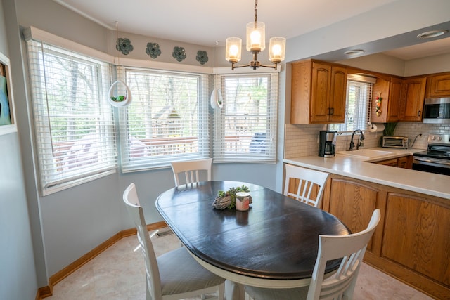 dining room with a toaster, an inviting chandelier, and baseboards