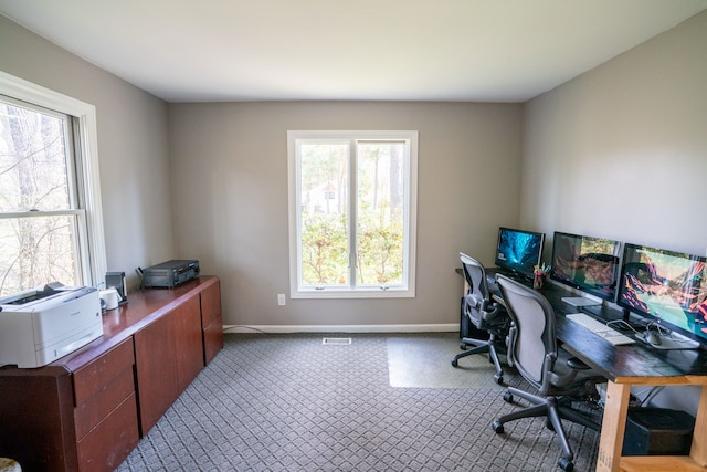carpeted office with a wealth of natural light, visible vents, and baseboards