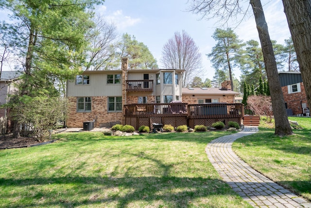back of house with a lawn, a wooden deck, and brick siding