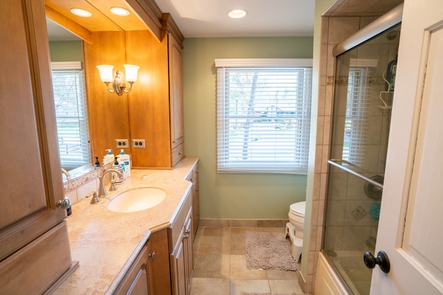 bathroom featuring a healthy amount of sunlight, toilet, tile patterned flooring, and vanity